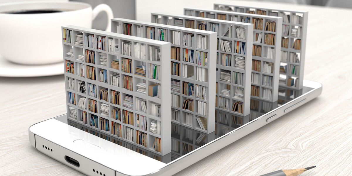  Photo: Bookcase with books on a smartphone screen on a desktop, © iStock.com - ​Julia Garan